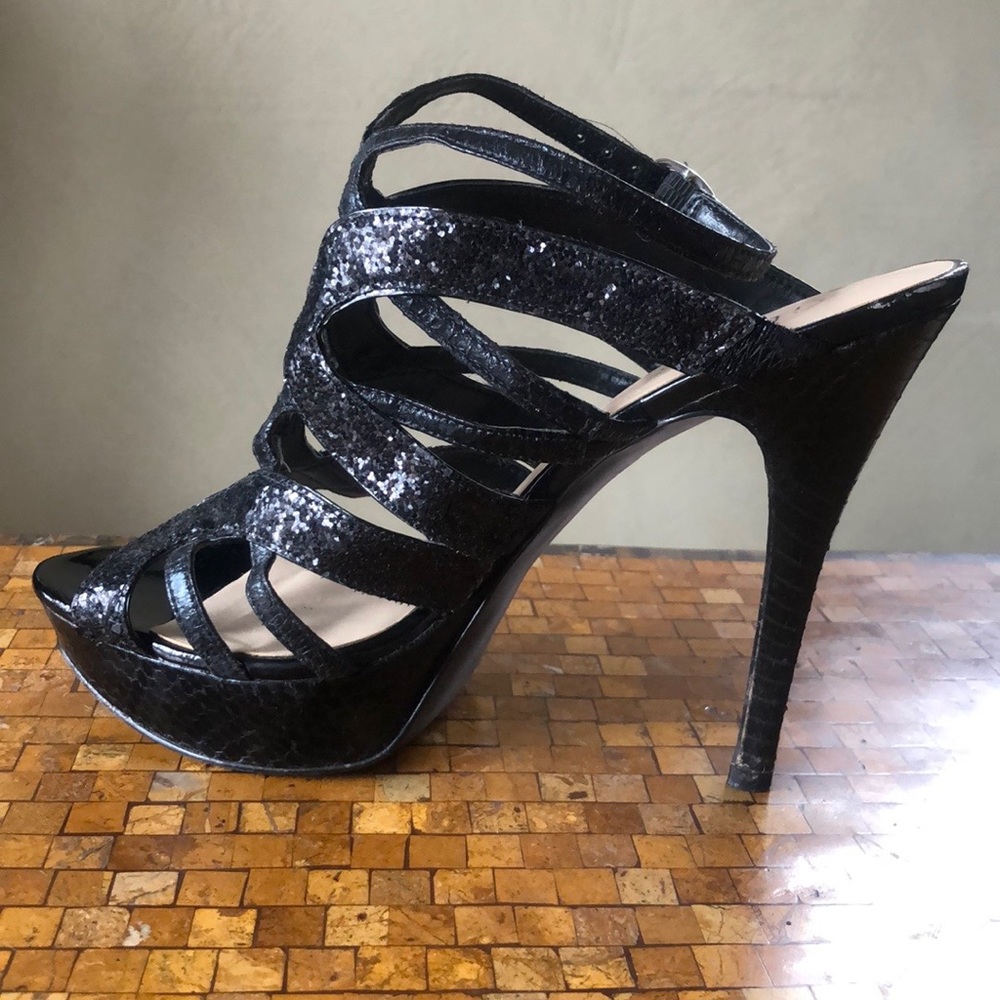 Platform front strappy black glitter heels.